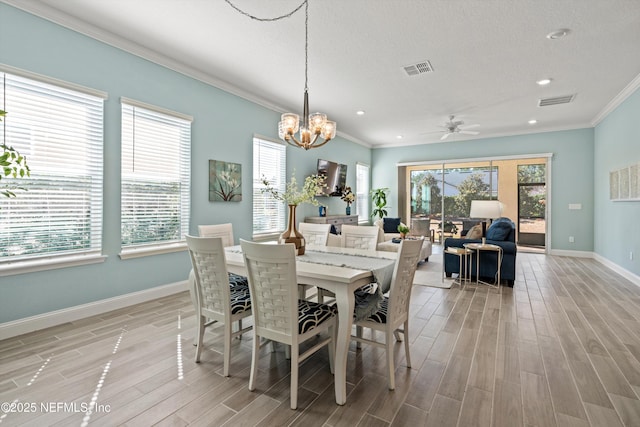 dining area featuring ceiling fan with notable chandelier, crown molding, and a textured ceiling