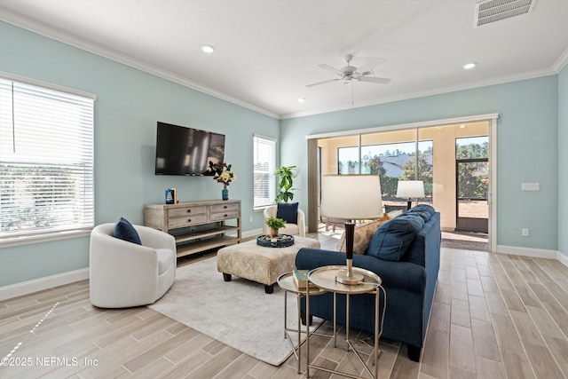 living room with ceiling fan, crown molding, and a healthy amount of sunlight