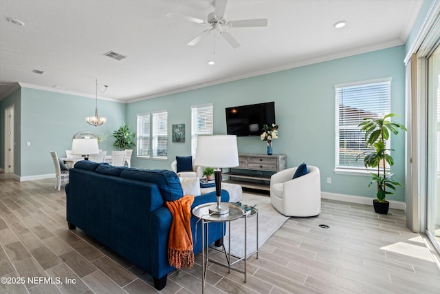 living room featuring ceiling fan with notable chandelier and ornamental molding