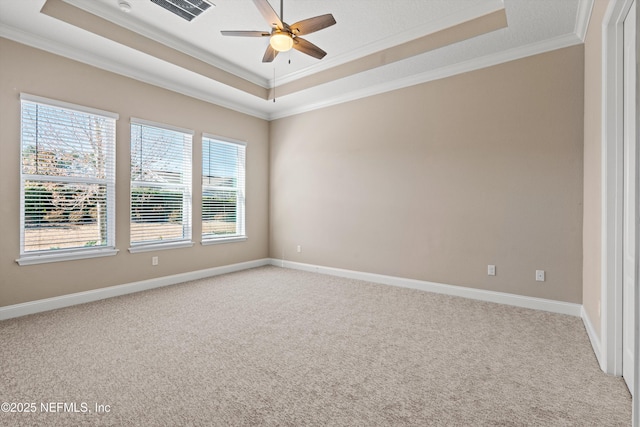 spare room featuring a tray ceiling, ornamental molding, carpet flooring, and ceiling fan