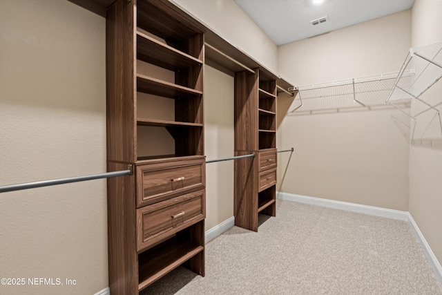 walk in closet featuring light colored carpet