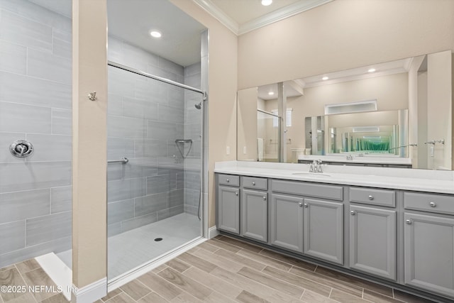 bathroom with vanity, crown molding, and tiled shower