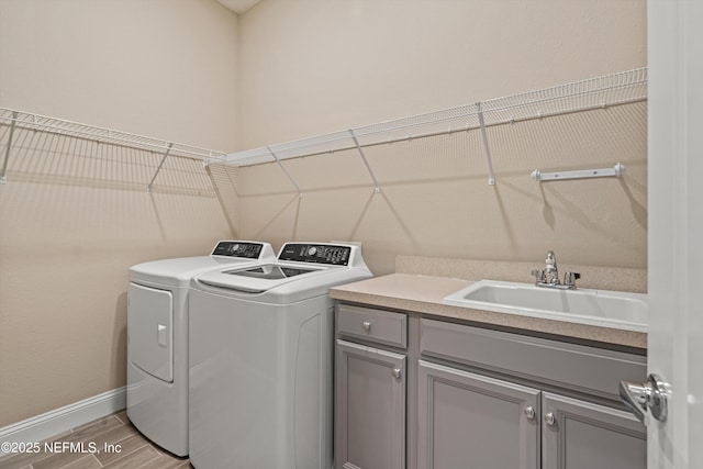 washroom with cabinets, sink, and separate washer and dryer