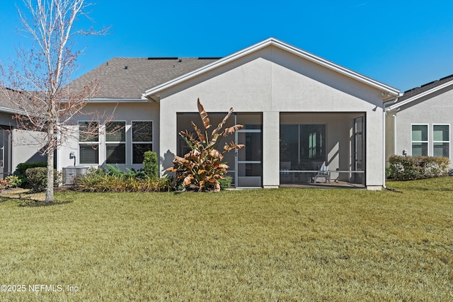 rear view of property featuring cooling unit, a sunroom, and a lawn