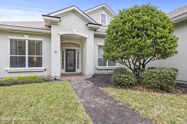 doorway to property with a yard