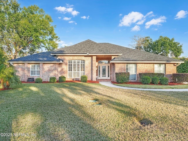 view of front of property with a front lawn and central AC