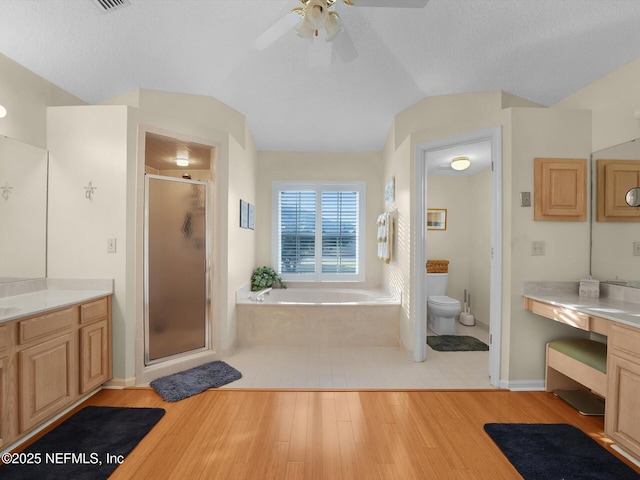 full bathroom with toilet, vanity, independent shower and bath, and lofted ceiling