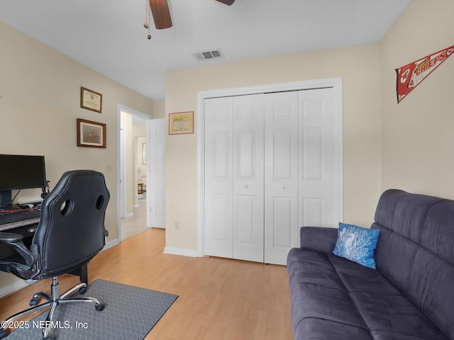 office with ceiling fan and light hardwood / wood-style flooring