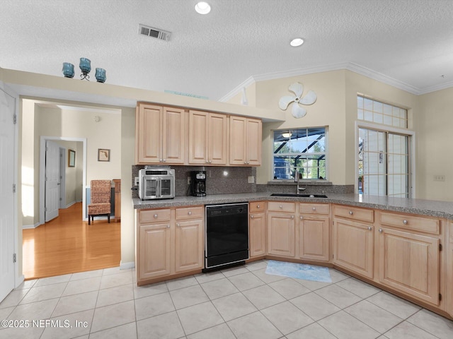 kitchen with a textured ceiling, dishwasher, light brown cabinetry, sink, and light tile patterned floors