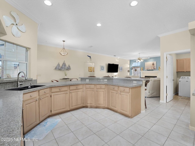 kitchen featuring washer / dryer, ornamental molding, light brown cabinets, and sink