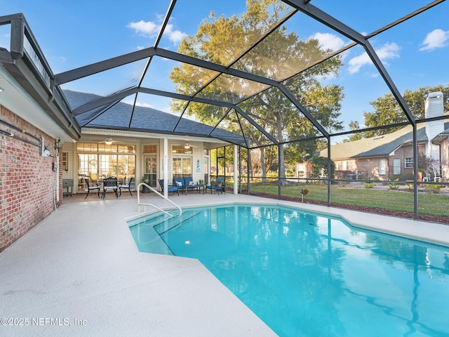 view of pool with ceiling fan, a lanai, and a patio