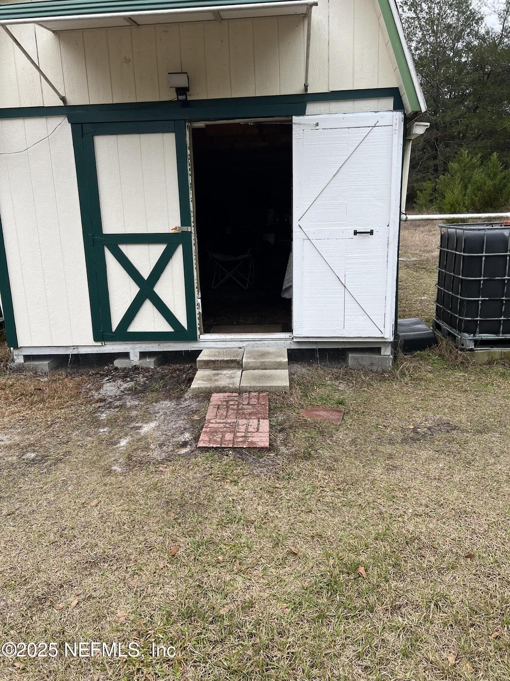 view of outdoor structure featuring central AC and a yard