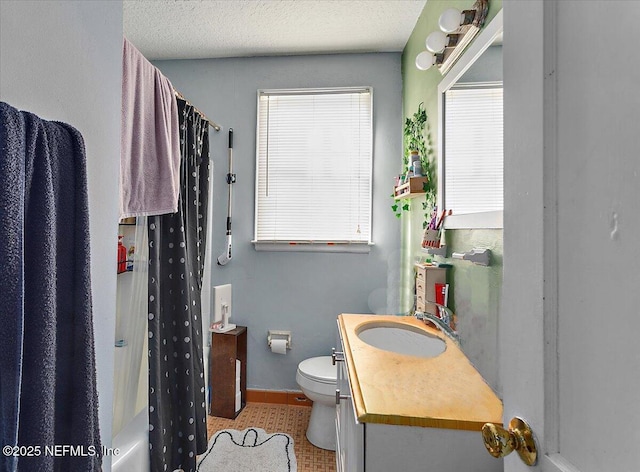 full bathroom with vanity, shower / bath combination with curtain, a textured ceiling, tile patterned floors, and toilet