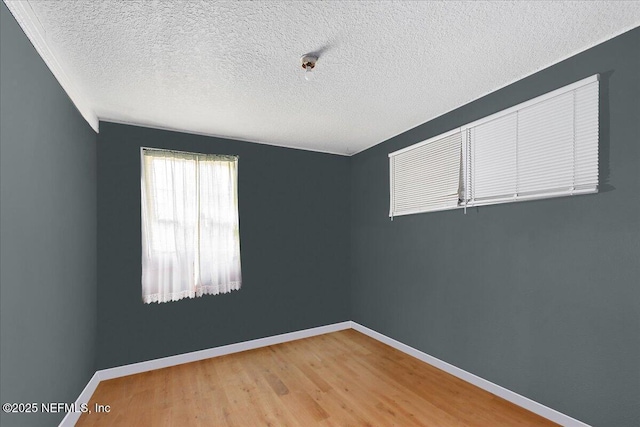 empty room with wood-type flooring and a textured ceiling