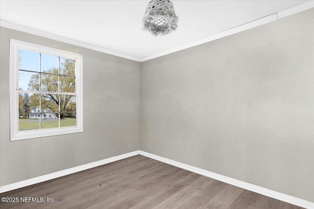 empty room with hardwood / wood-style flooring and ornamental molding