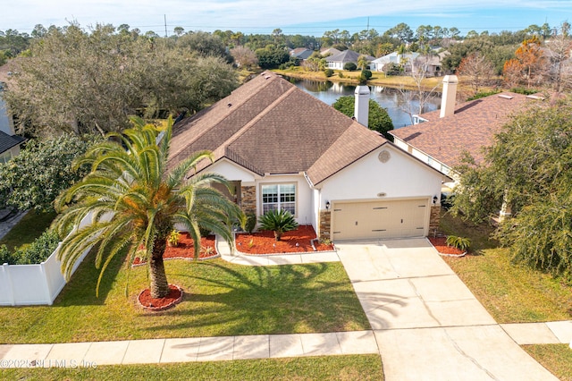 view of front of property with a water view, a garage, and a front lawn