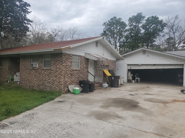 view of property exterior featuring entry steps, driveway, and brick siding