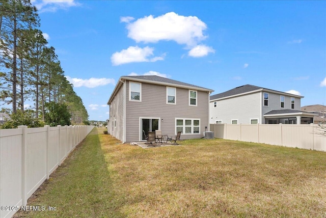 rear view of house with a patio area, cooling unit, and a lawn