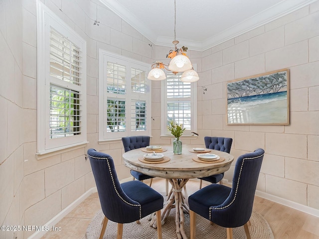 dining space featuring ornamental molding, a wealth of natural light, light hardwood / wood-style floors, and tile walls