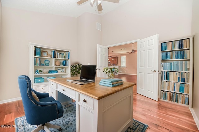 home office with ceiling fan, a textured ceiling, and light hardwood / wood-style floors