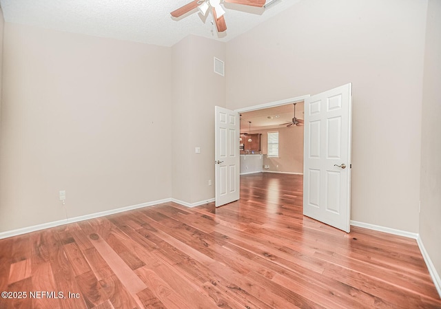 empty room featuring wood-type flooring, ceiling fan, and a textured ceiling