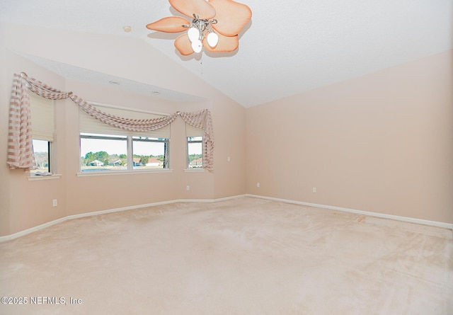 empty room featuring carpet floors, a textured ceiling, vaulted ceiling, and ceiling fan