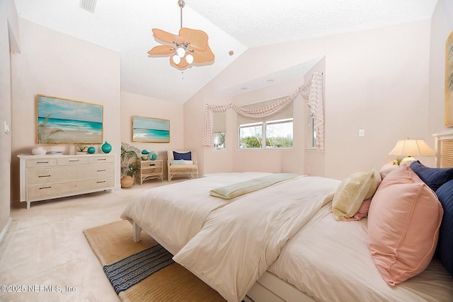 bedroom featuring lofted ceiling, a textured ceiling, light colored carpet, and ceiling fan