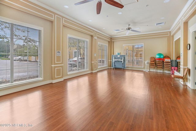 exercise area with crown molding, ceiling fan, and wood-type flooring