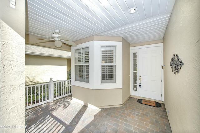 view of exterior entry featuring ceiling fan