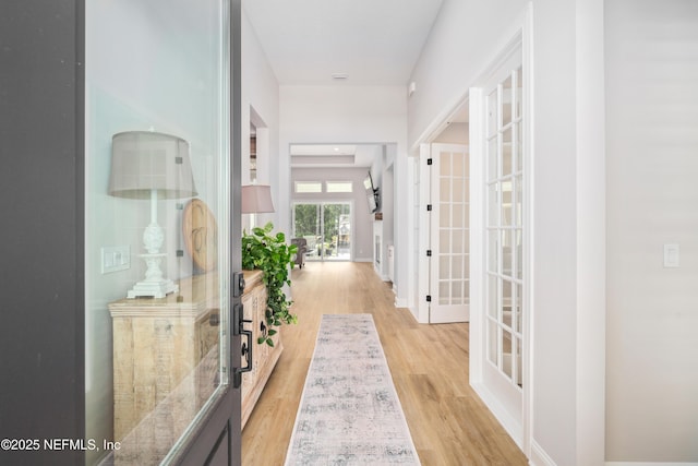 hallway featuring french doors and light hardwood / wood-style flooring