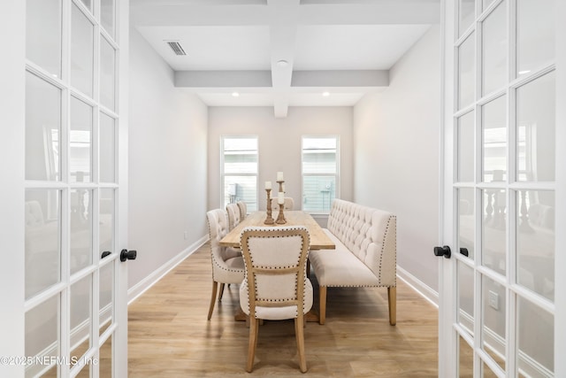 dining space featuring coffered ceiling, light hardwood / wood-style floors, french doors, and beamed ceiling