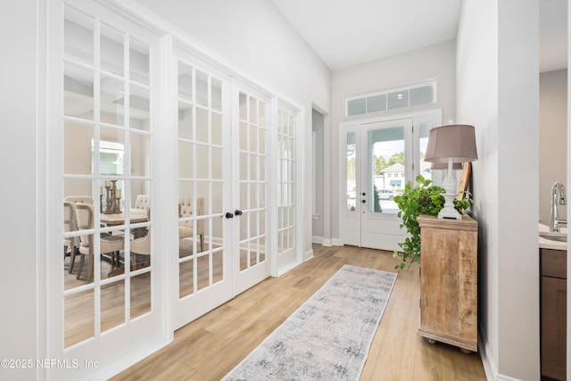 entryway featuring french doors, sink, and light hardwood / wood-style floors