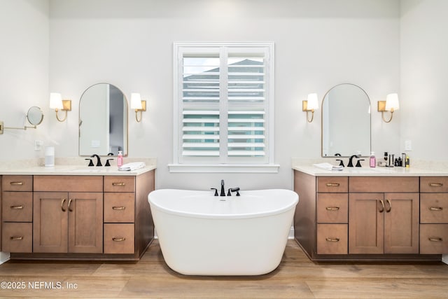 bathroom featuring vanity, a bath, and hardwood / wood-style floors