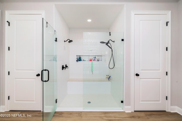 bathroom featuring hardwood / wood-style flooring and a shower with shower door