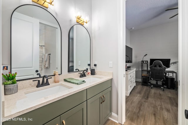 bathroom with hardwood / wood-style flooring, vanity, and a textured ceiling