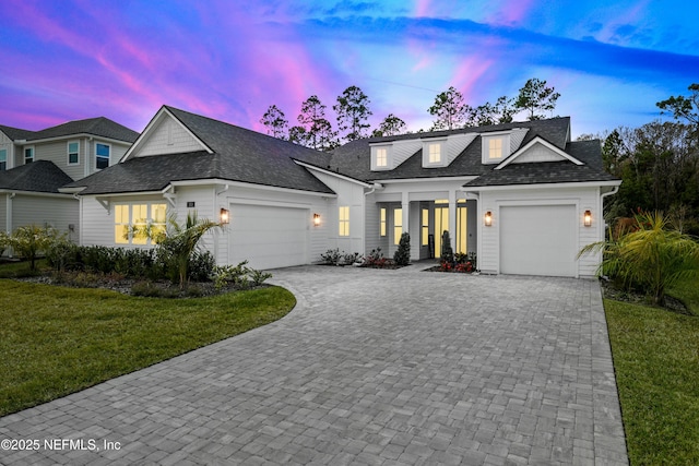 view of front of home with a garage and a lawn