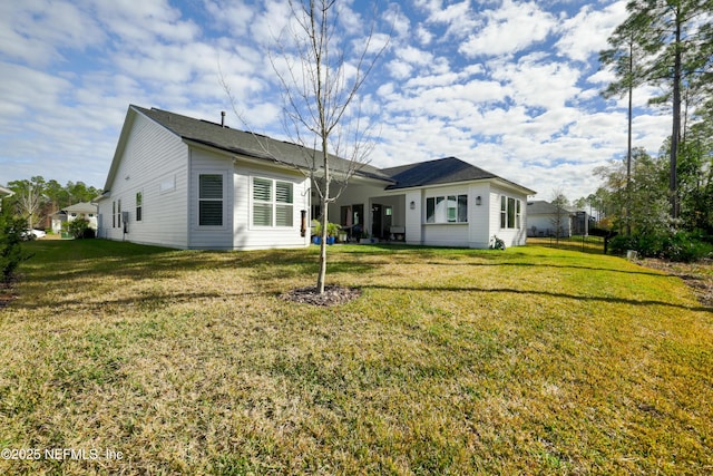 rear view of property featuring a lawn