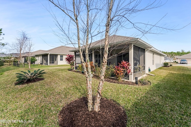 rear view of property with a yard and a sunroom