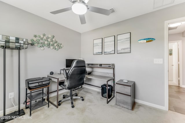 office space featuring light carpet and ceiling fan