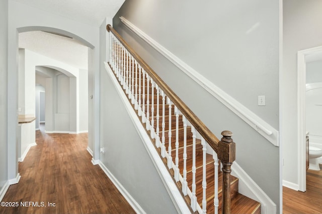 staircase with hardwood / wood-style flooring and a textured ceiling