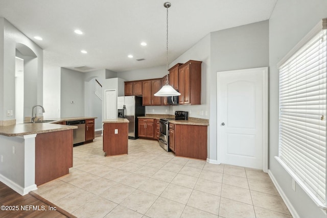 kitchen featuring light tile patterned floors, sink, kitchen peninsula, pendant lighting, and stainless steel appliances