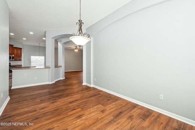 unfurnished dining area featuring dark hardwood / wood-style floors and ceiling fan