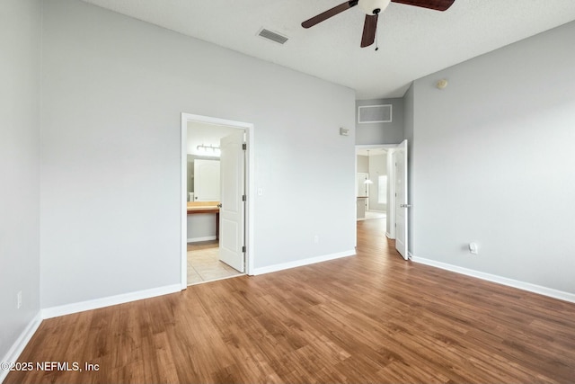 unfurnished bedroom with ceiling fan, light hardwood / wood-style floors, and connected bathroom