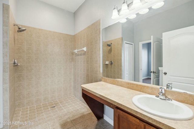 bathroom featuring a tile shower, an inviting chandelier, tile patterned flooring, and vanity