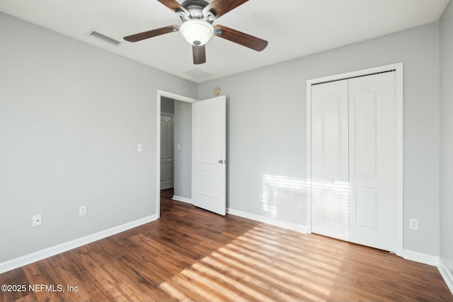 unfurnished bedroom with a closet, ceiling fan, and dark wood-type flooring