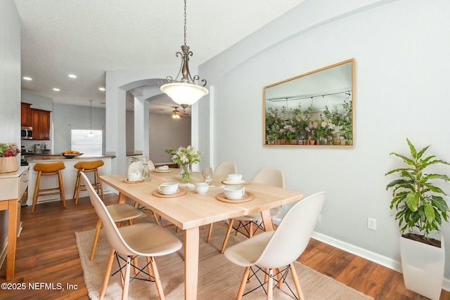 dining area with ceiling fan and dark wood-type flooring