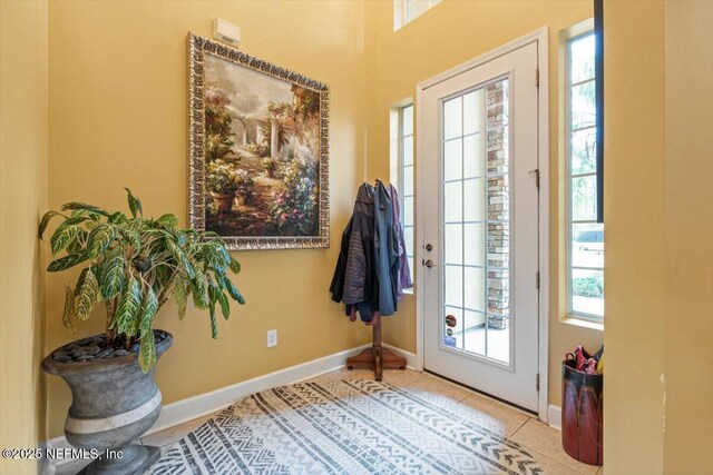 doorway with a healthy amount of sunlight and light tile patterned flooring