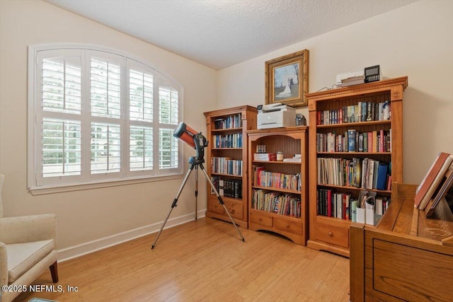 sitting room featuring light hardwood / wood-style floors and a textured ceiling