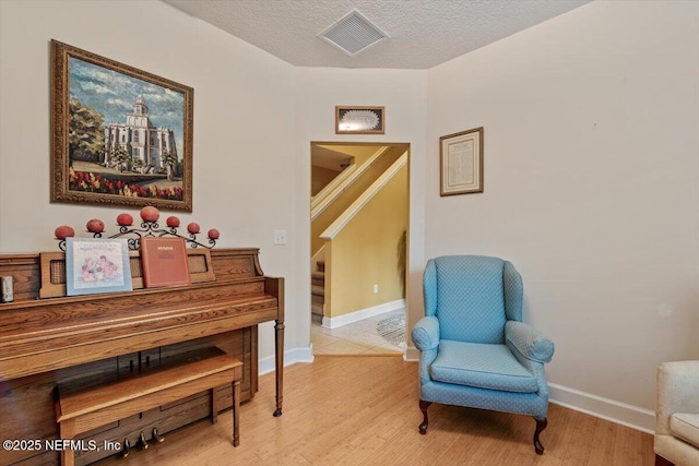 living area featuring light hardwood / wood-style flooring and a textured ceiling