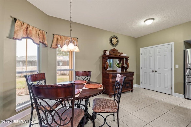 dining area with light tile patterned flooring and a textured ceiling